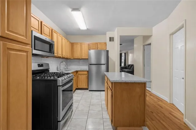 a kitchen with stainless steel appliances granite countertop a stove a refrigerator and a refrigerator