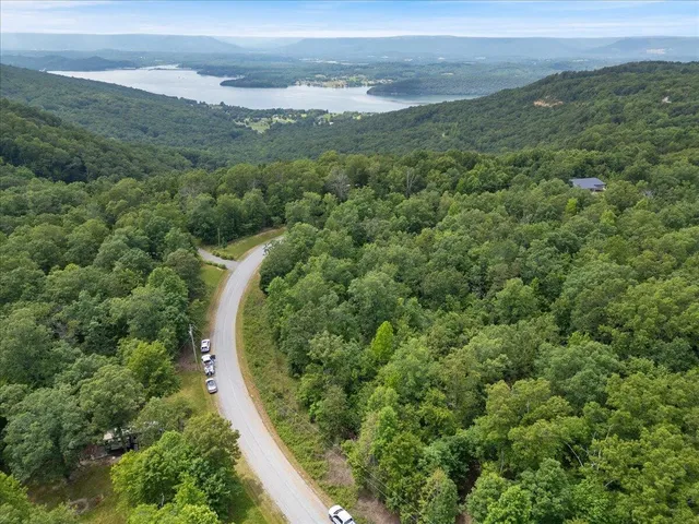 an aerial view of a residential houses with outdoor space and trees
