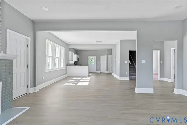 a view of a hallway with wooden floor and a living room