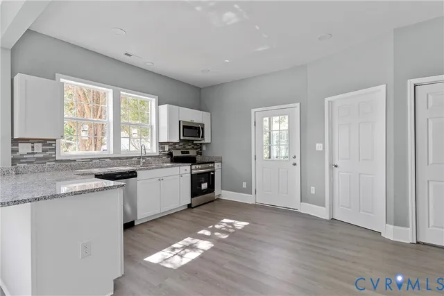 a kitchen with granite countertop a stove a sink and a refrigerator