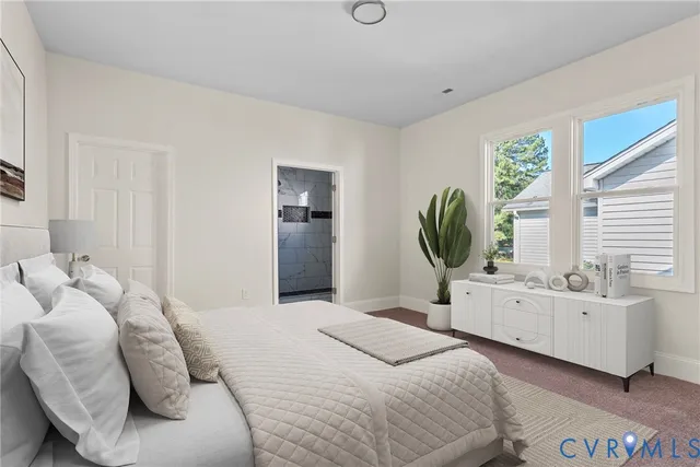 a bedroom with a bed mirror and window