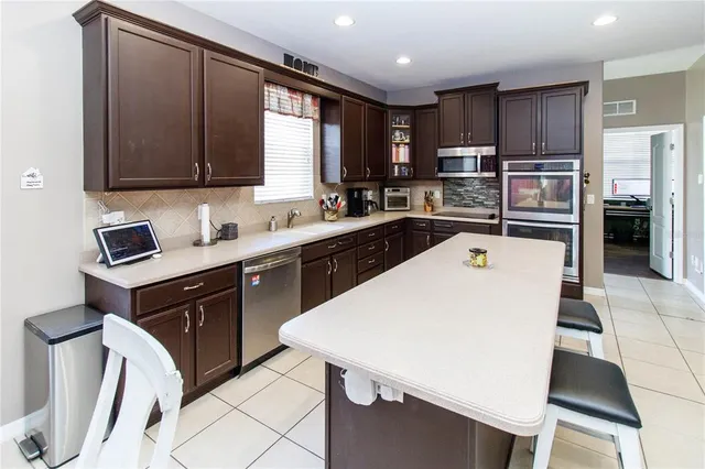 a kitchen with stainless steel appliances a sink and a refrigerator