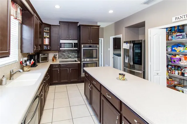 a kitchen with a sink a stove top oven and white kitchen
