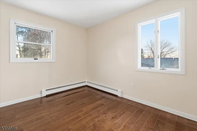 an empty room with wooden floor and window
