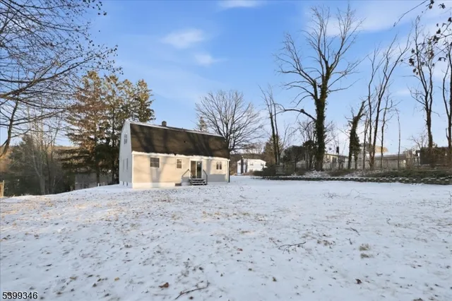 a view of white house with snow on the road