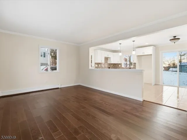 a view of a kitchen with wooden floor and a window