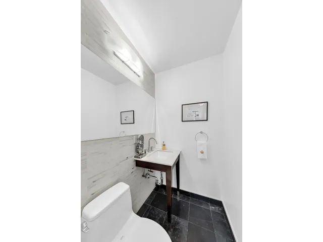 a kitchen with a stove a sink dishwasher and white cabinets with wooden floor