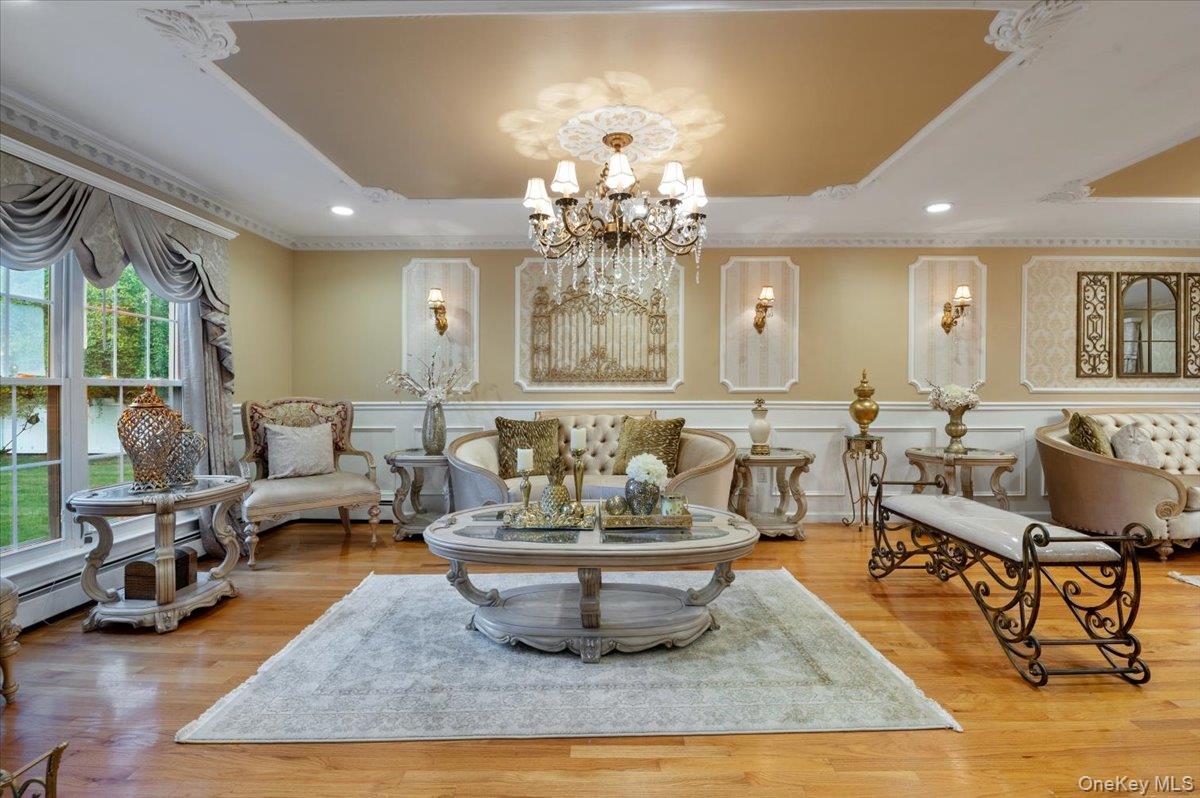 626 Caledonia Road Dix Hills, NY 11746 - Photo 11 of 50 Sitting room featuring a tray ceiling, wood finished floors, a chandelier, recessed lighting, and a baseboard radiator