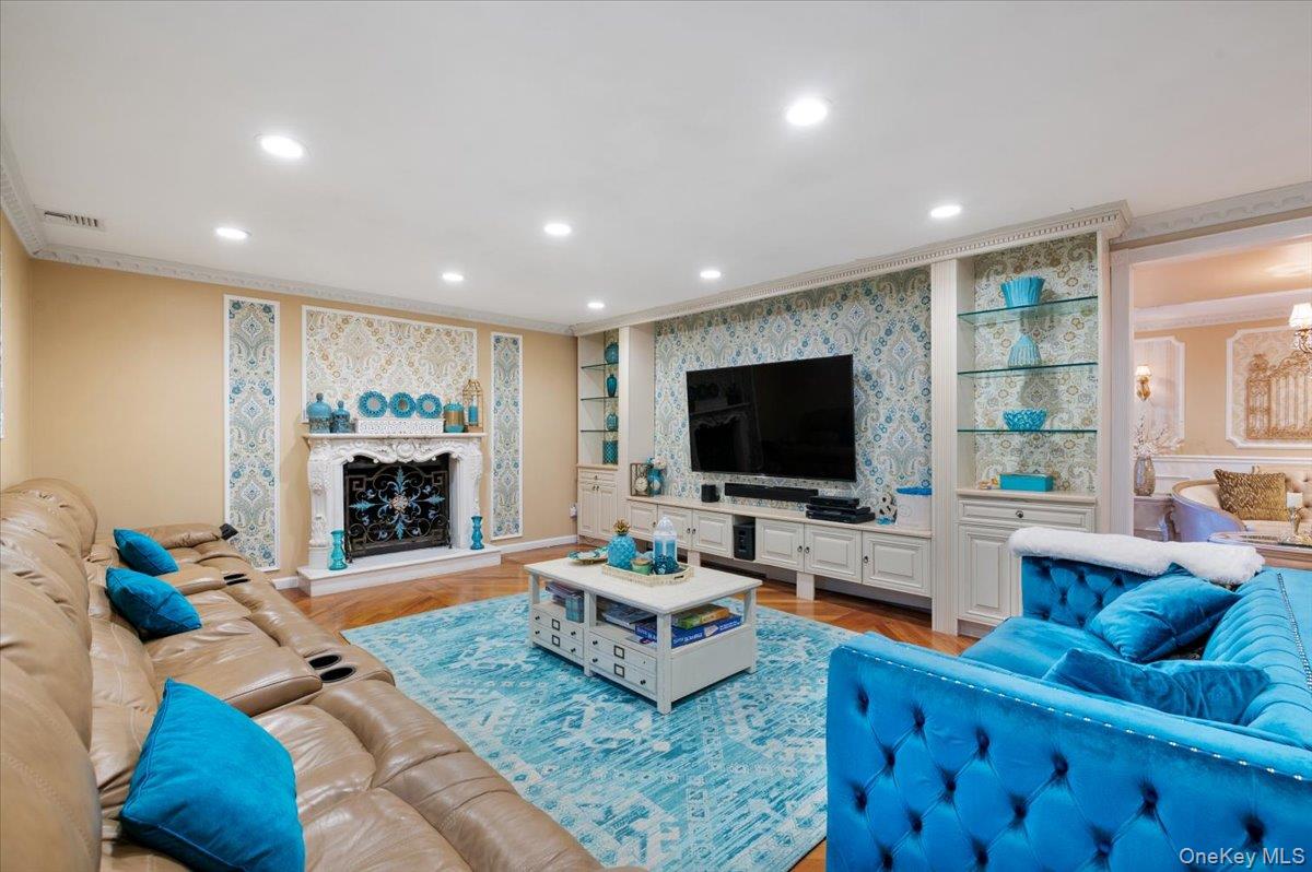 626 Caledonia Road Dix Hills, NY 11746 - Photo 13 of 50 Living area featuring built in shelves, recessed lighting, crown molding, wallpapered walls, and light wood-style flooring