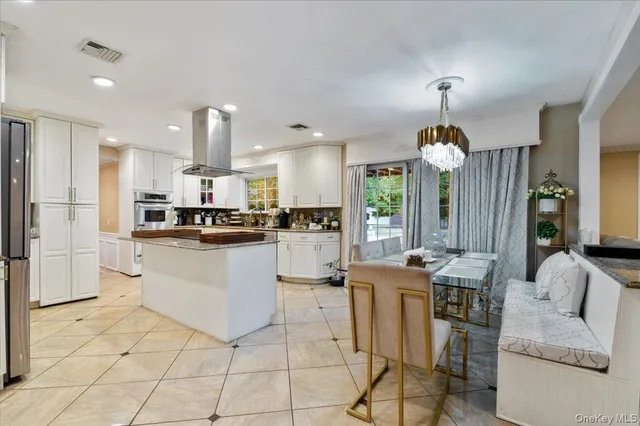 a kitchen with stainless steel appliances kitchen island granite countertop a sink and cabinets