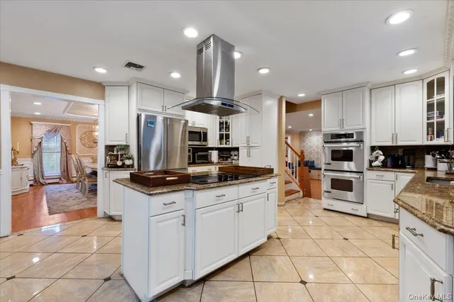 a kitchen with stainless steel appliances kitchen island granite countertop a stove and a sink