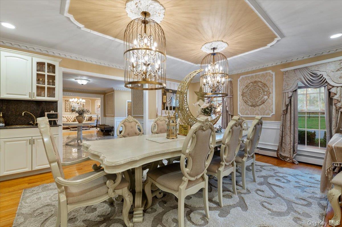 626 Caledonia Road Dix Hills, NY 11746 - Photo 21 of 50 Dining room featuring wainscoting, light wood-type flooring, a decorative wall, recessed lighting, and a chandelier