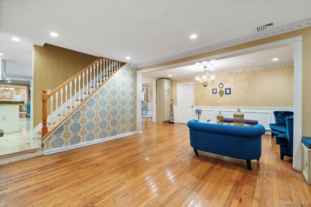 626 Caledonia Road Dix Hills, NY 11746 - Photo 23 of 50 Living room featuring a chandelier, light wood-type flooring, stairway, a decorative wall, and recessed lighting
