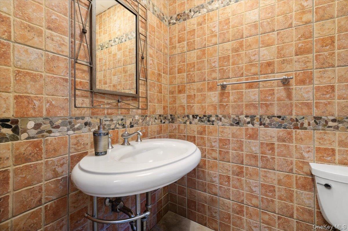 626 Caledonia Road Dix Hills, NY 11746 - Photo 24 of 50 Half bath featuring tile walls and a sink