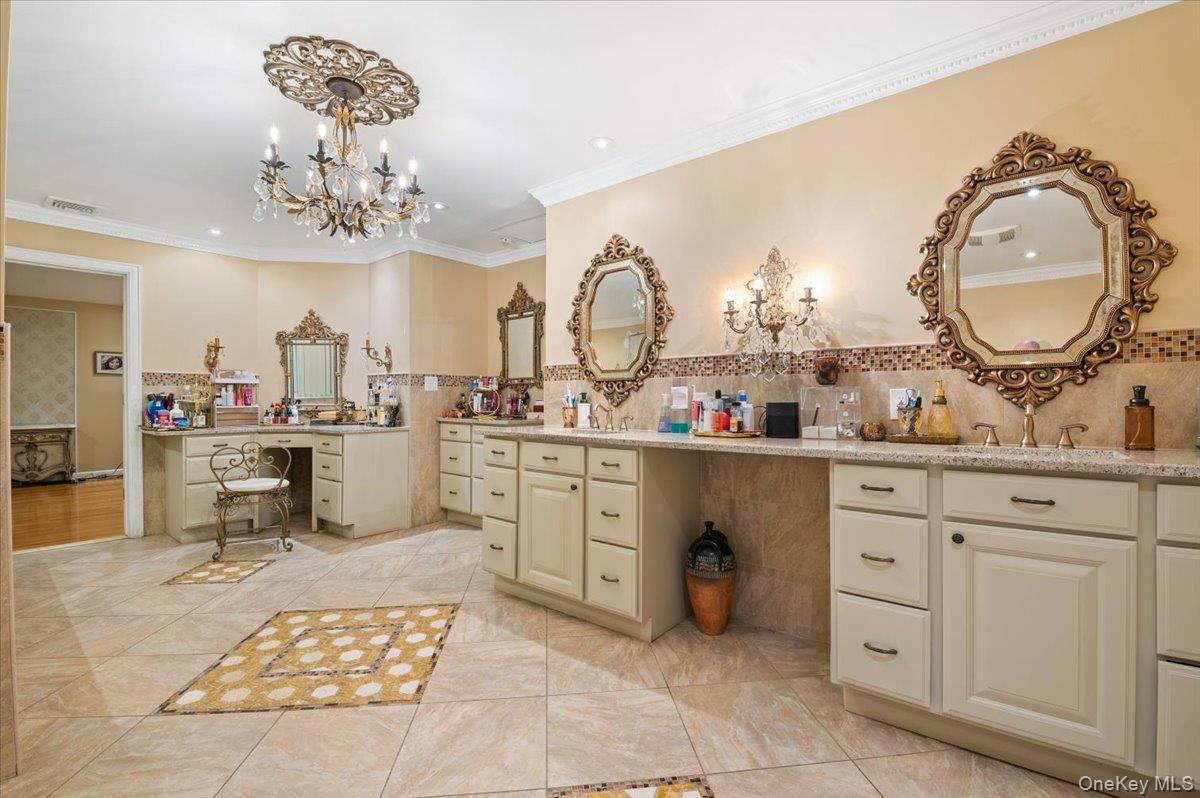 626 Caledonia Road Dix Hills, NY 11746 - Photo 28 of 50 Full bathroom with double vanity, crown molding, light tile patterned floors, a chandelier, and decorative backsplash
