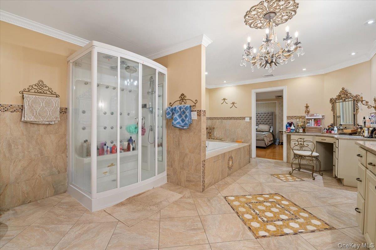 626 Caledonia Road Dix Hills, NY 11746 - Photo 29 of 50 Full bath with vanity, a garden tub, tile walls, crown molding, and a stall shower