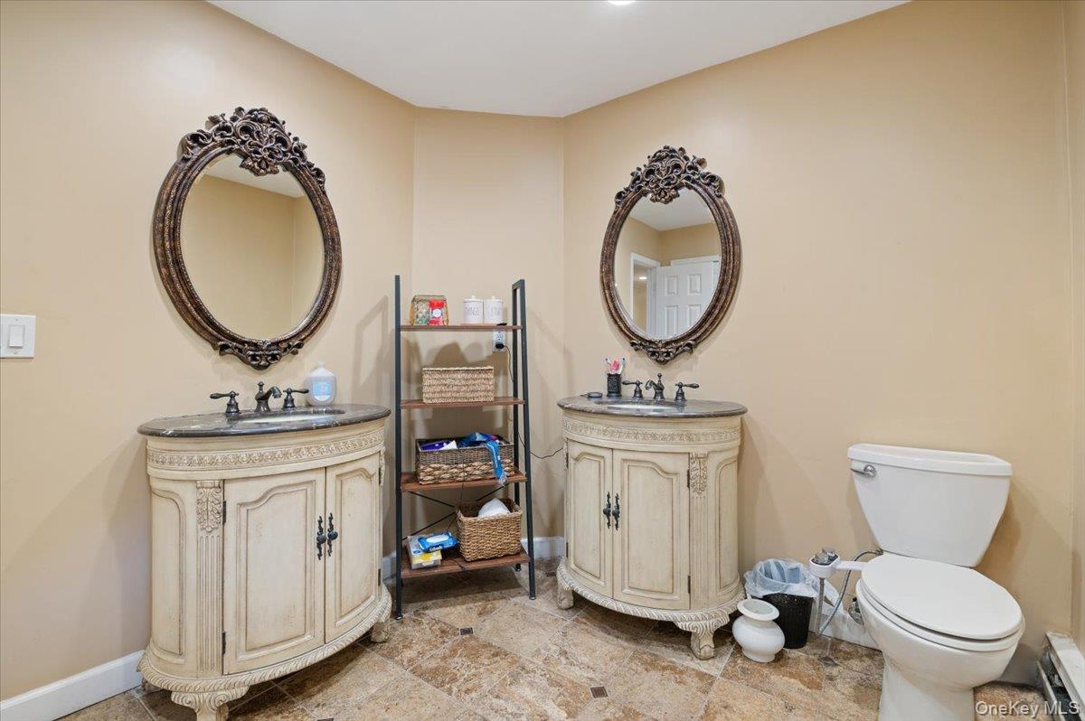 626 Caledonia Road Dix Hills, NY 11746 - Photo 32 of 50 Bathroom featuring two vanities and a baseboard heating unit