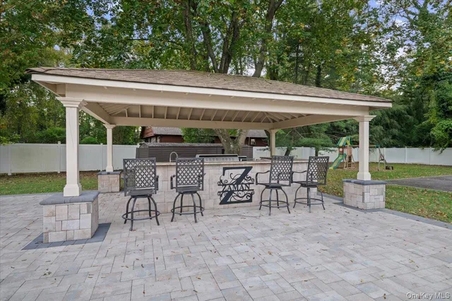 a view of a patio with table and chairs potted plants and a large tree