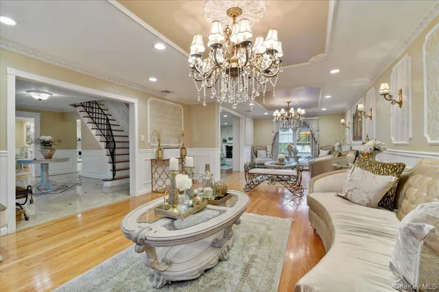 a living room with furniture a chandelier and a dining room
