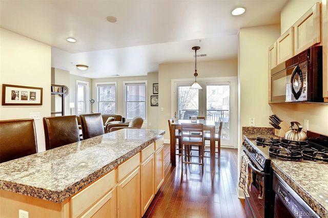 a large kitchen with kitchen island a stove a sink a dining table and chairs