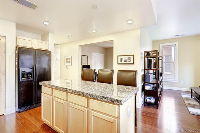 a kitchen with stainless steel appliances granite countertop a refrigerator and a sink