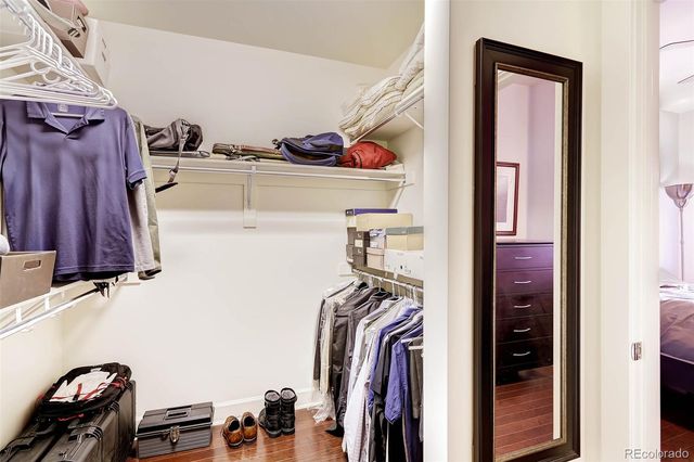 a view of walk in closet with clothes and shoes