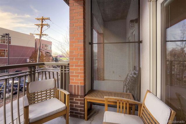a balcony with wooden floor and outdoor seating