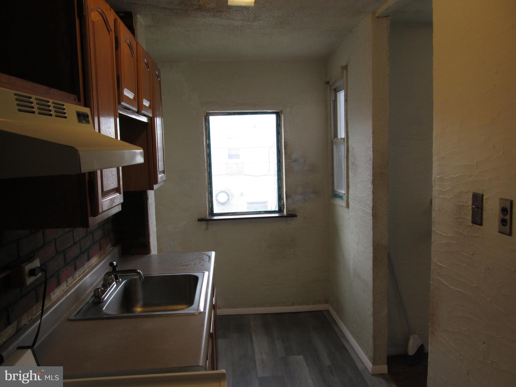 644 Copley Road Upper Darby, PA 19082 - Photo 21 of 47 a kitchen with a sink wooden cabinets and a microwave