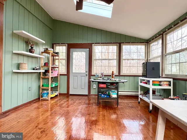 a view of game room with window and wooden floor