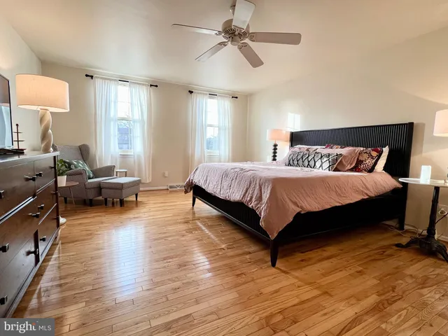 a bedroom with a bed wooden floor and window