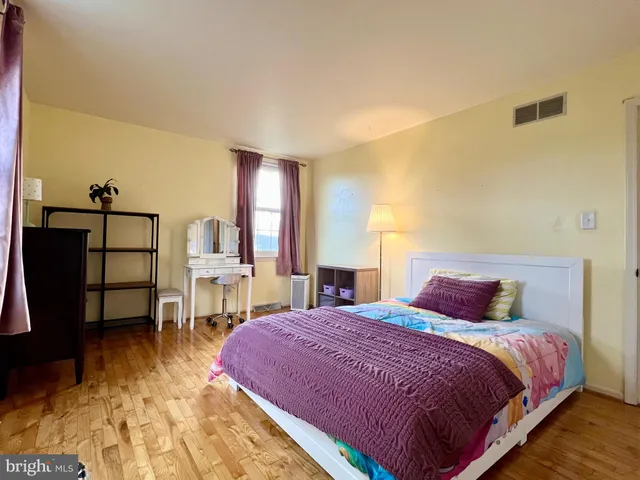 a bedroom with a bed table and chair