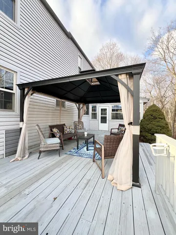 an outdoor sitting area with furniture and wooden floor