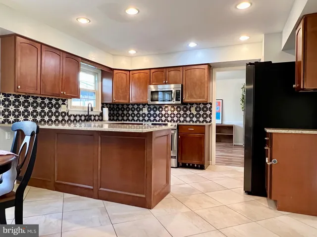 a kitchen with stainless steel appliances granite countertop a refrigerator a sink a stove a microwave a counter top and cabinets