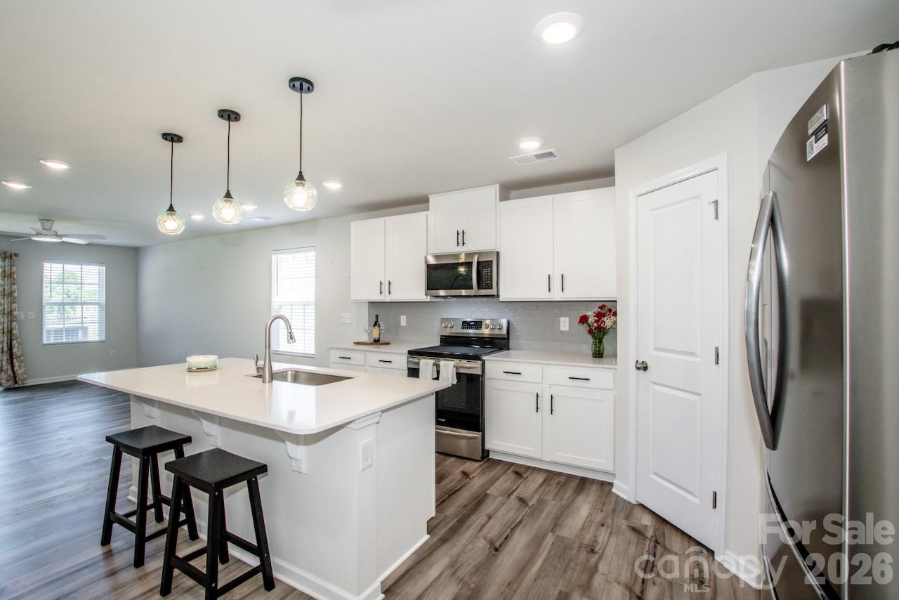 2742 Legacy Ridge Lane Catawba, NC 28609 - Photo 16 of 36 a kitchen with stainless steel appliances granite countertop a refrigerator a sink dishwasher a stove and white countertops with wooden floor