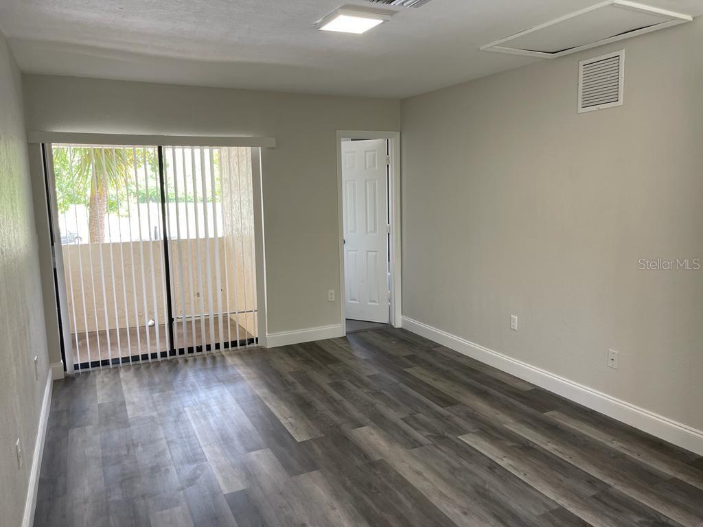 10260 Turkey Lake Road, Unit 150 (A30) Orlando, FL 32819 - Photo 8 of 13 an empty room with wooden floor and windows