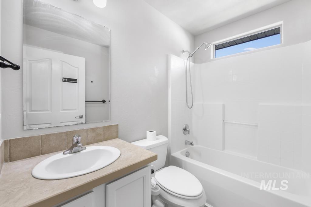 1183 Cortes Loop Twin Falls, ID 83301 - Photo 14 of 30 Bathroom featuring a white vanity with an oval undermount sink, a beige countertop, and a tiled backsplash
