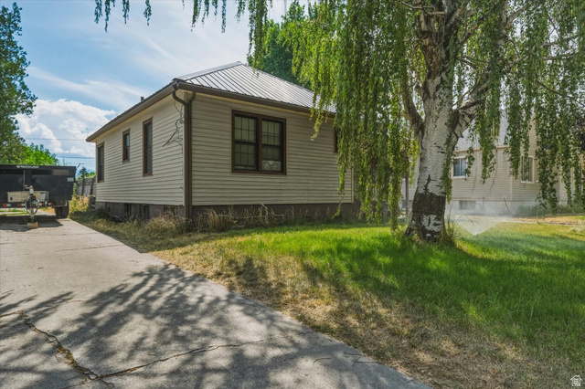 226 North State Street Preston, ID 83263 - Photo 3 of 18 Exterior siding with dark trim windows, metal roof, and concrete driveway