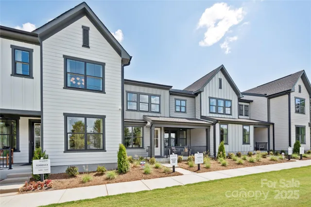 a front view of a house with swimming pool and chairs