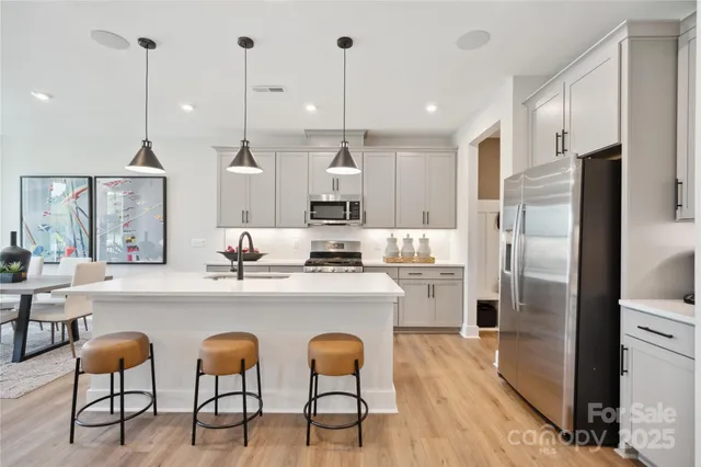 a kitchen with refrigerator and chairs