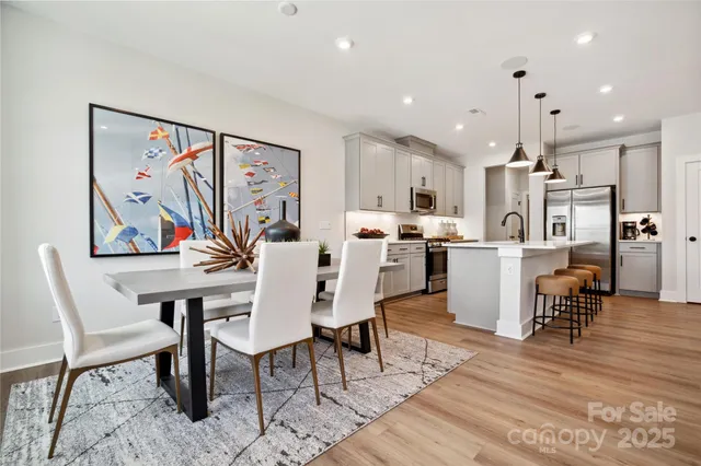 a living room with stainless steel appliances kitchen island granite countertop furniture and a dining table
