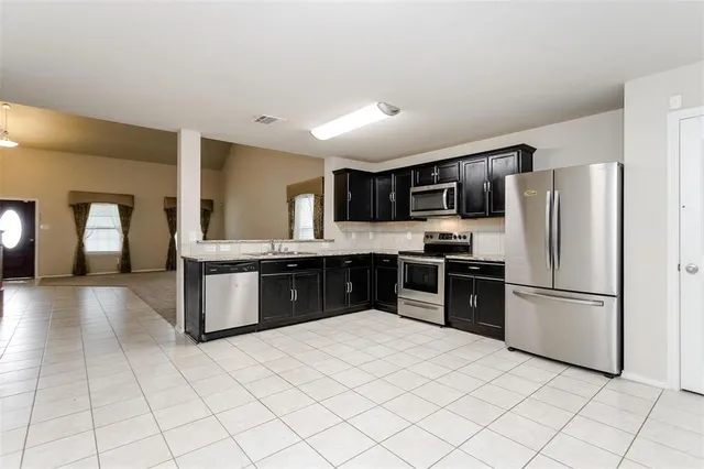 a large kitchen with a sink and cabinets