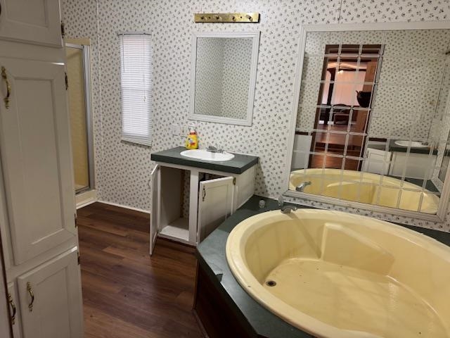 367 Eldie Foster Road Pocahontas, TN 38061 - Photo 10 of 14 Bathroom featuring wood finished floors, vanity, wallpapered walls, a stall shower, and a bath