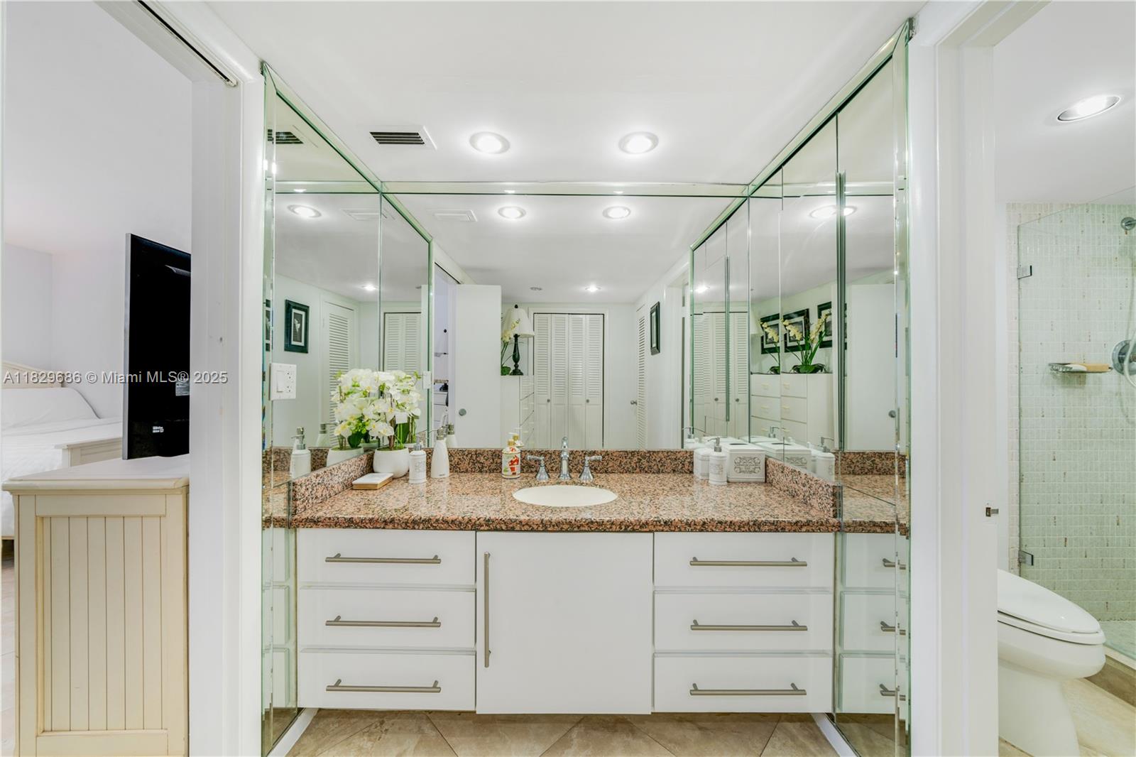 609 Ocean Drive, Unit 5H Key Biscayne, FL 33149 - Photo 19 of 28 a bathroom with a granite countertop sink mirror vanity and toilet