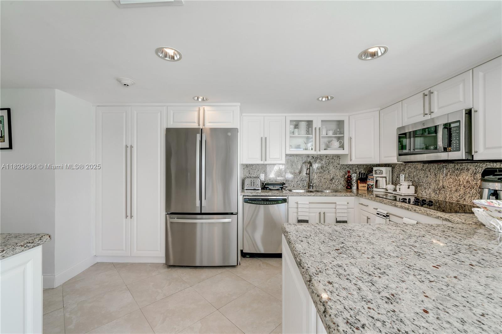 609 Ocean Drive, Unit 5H Key Biscayne, FL 33149 - Photo 20 of 28 a kitchen with granite countertop a refrigerator and a sink