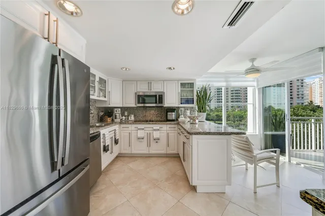 a kitchen with stainless steel appliances granite countertop a refrigerator and a stove top oven