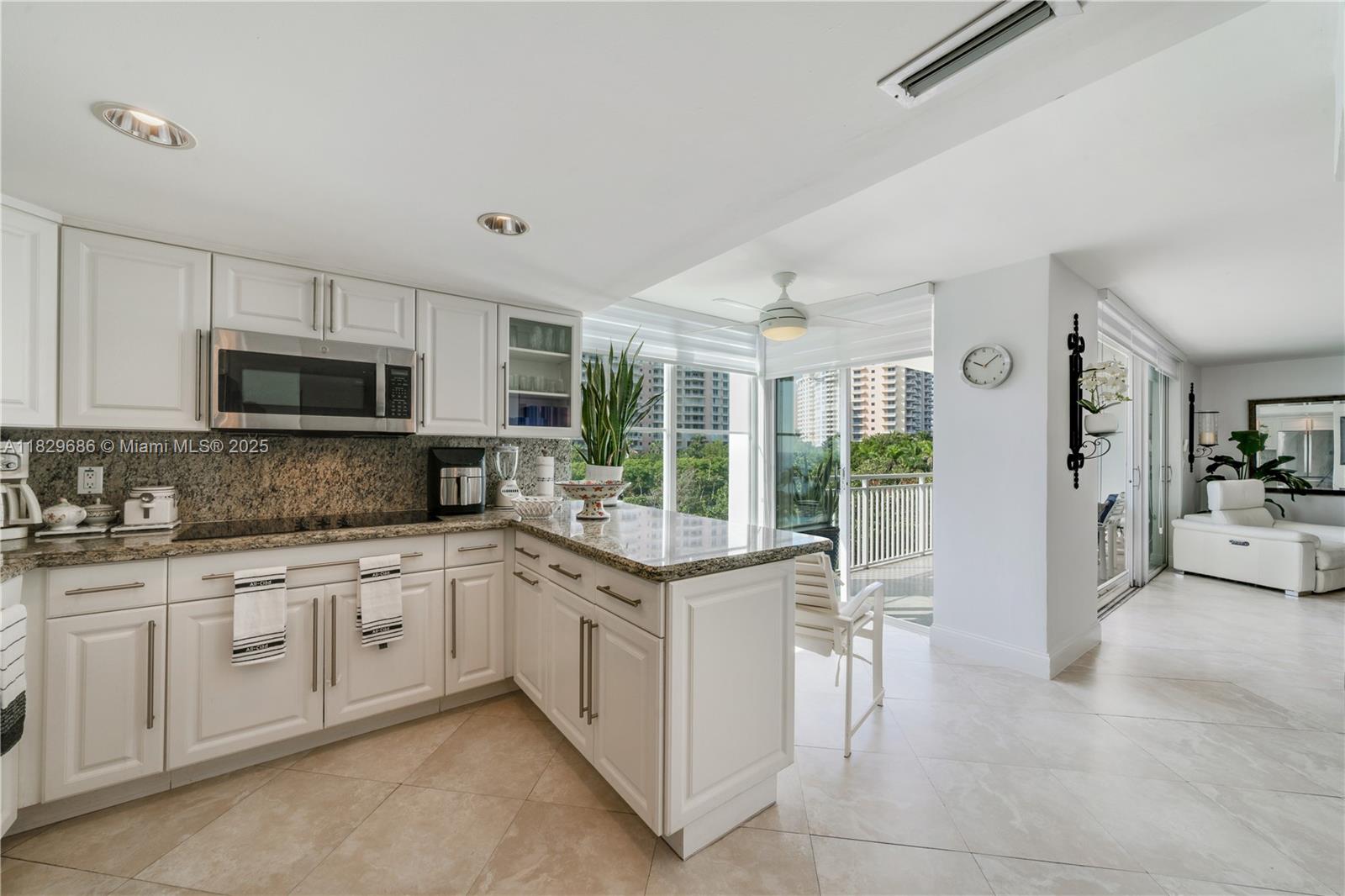 609 Ocean Drive, Unit 5H Key Biscayne, FL 33149 - Photo 22 of 28 a open kitchen with granite countertop a sink and white cabinets