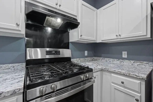 a kitchen with white cabinets and appliances