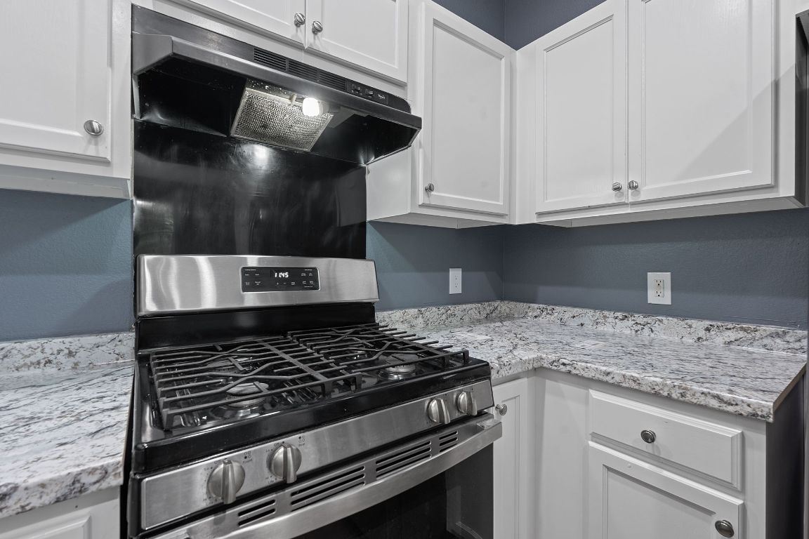 14517 Harris Ridge Boulevard, Unit B Pflugerville, TX 78660 - Photo 12 of 26 a kitchen with white cabinets and appliances