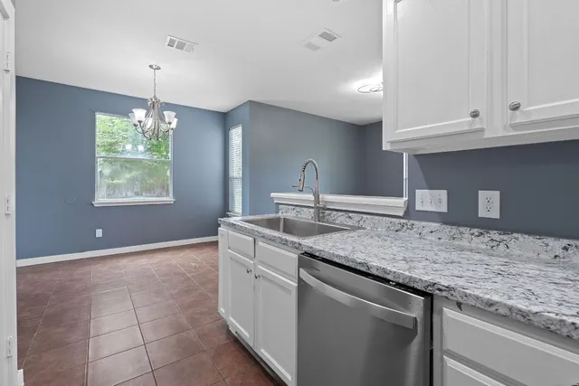 a kitchen with kitchen island granite countertop a sink and a stove