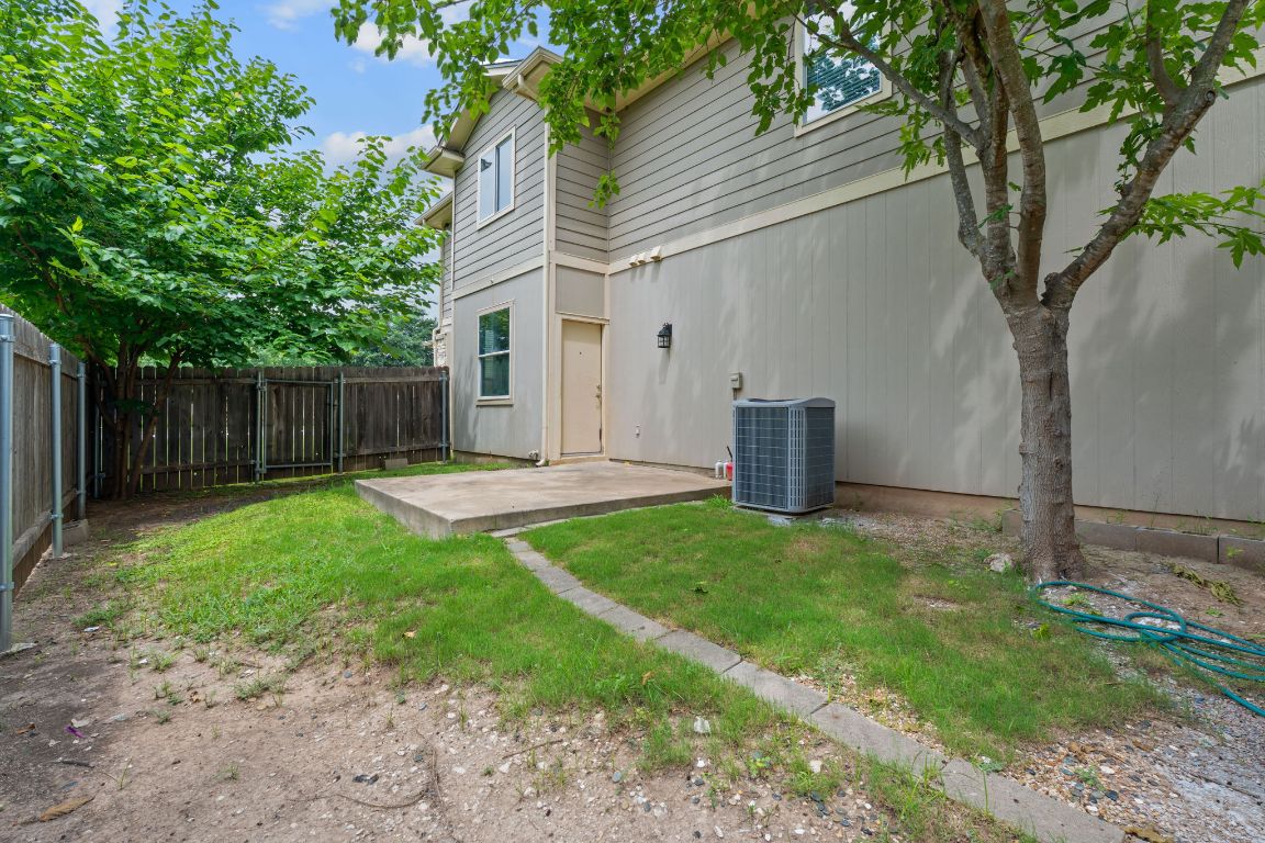 14517 Harris Ridge Boulevard, Unit B Pflugerville, TX 78660 - Photo 25 of 26 a backyard of a house with fountain plants and large tree